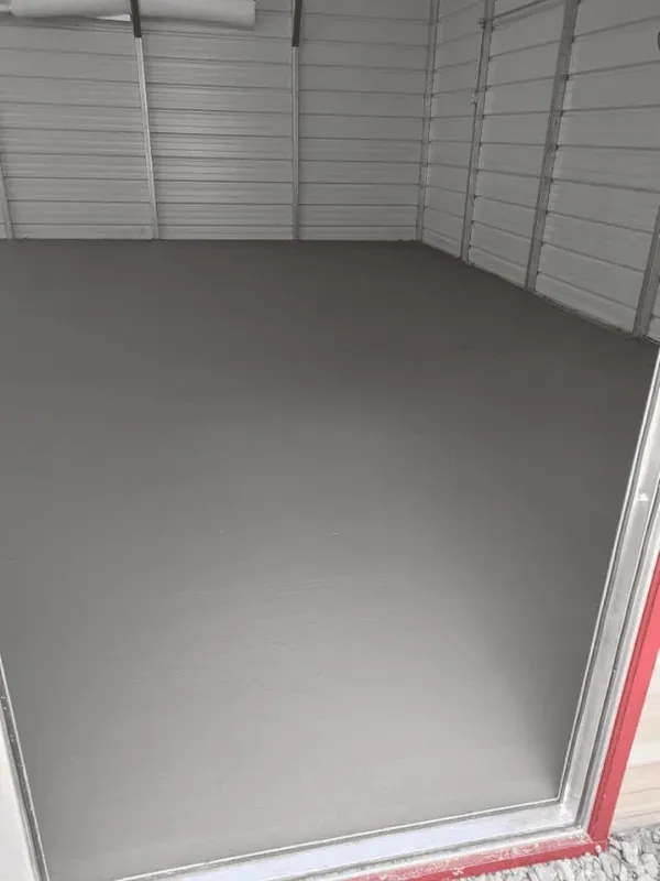Empty gray storage unit with white walls and a red door frame