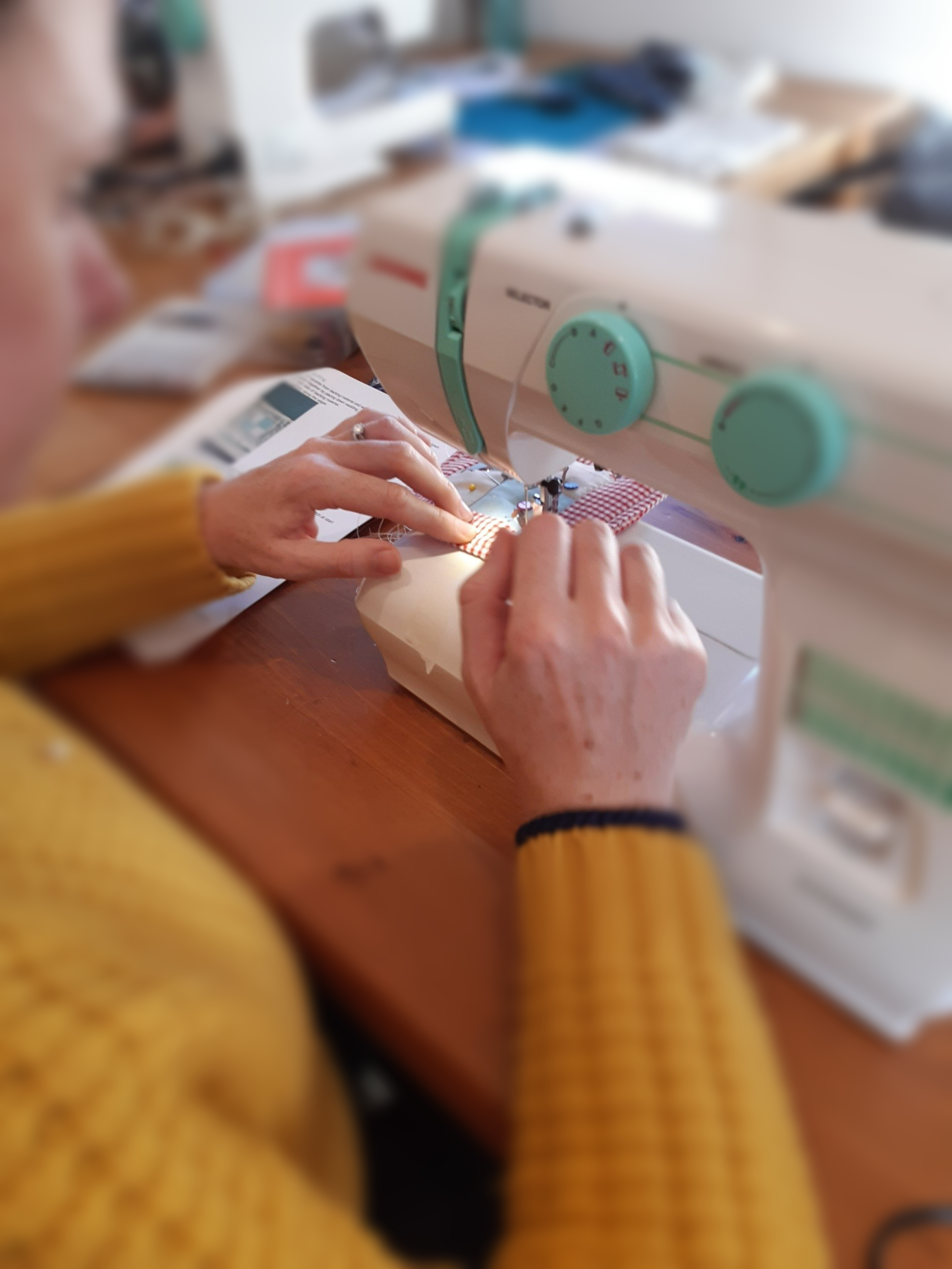 close up of hands at sewing machine