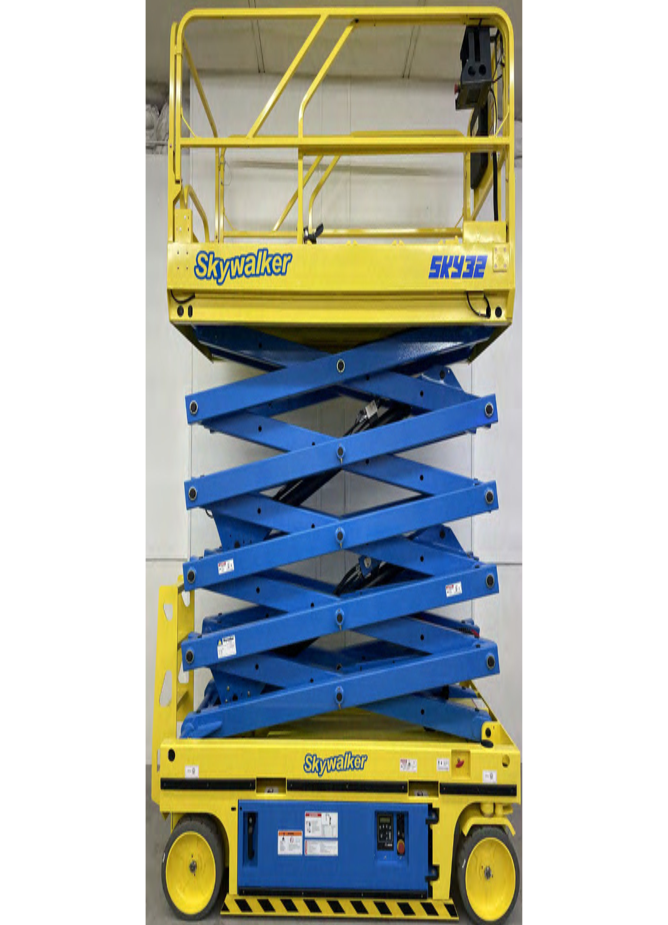 A blue and yellow scissor lift is sitting on top of a white surface.