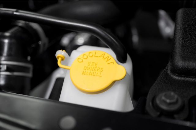 Yellow coolant reservoir cap in a car engine compartment