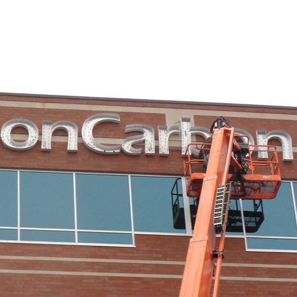 A person in an orange lift working on the