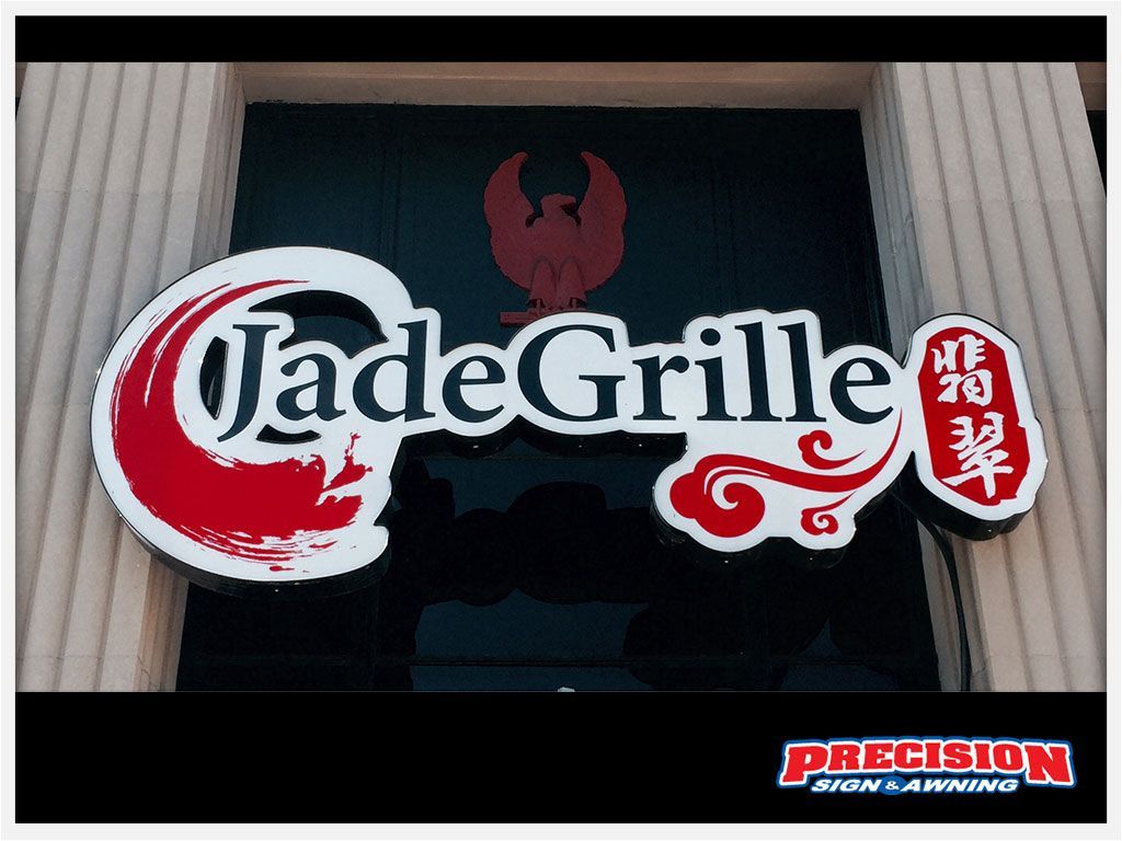 Jade Grille restaurant sign with red phoenix logo, white and red lettering, and ornate design.