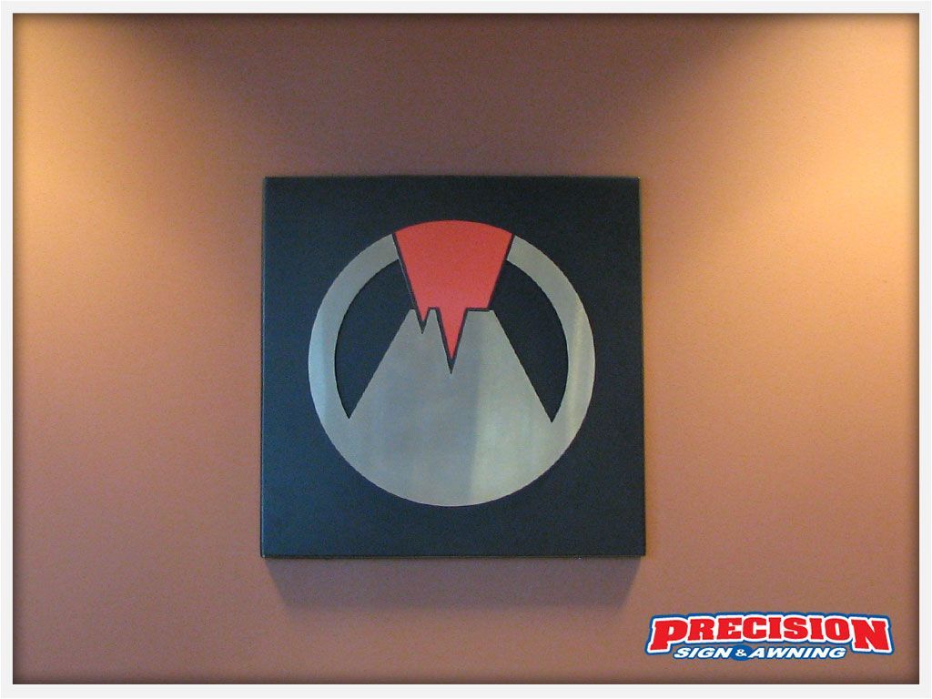 Logo on a wall: black square with silver circle and mountain, red triangle. "Precision Iron & Ammo" watermark.