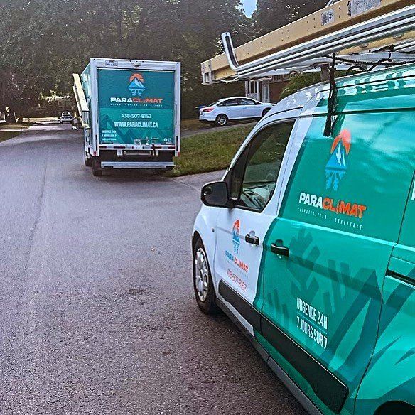 Une camionnette et un camion Para Climat blancs et turquoise dans une rue résidentielle.