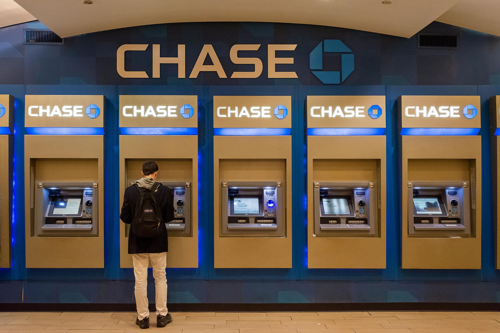 Person at Chase ATM, blue and tan bank interior.