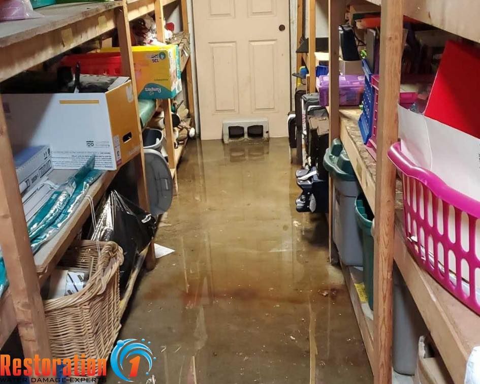 A flooded basement storage area with water covering the floor between wooden shelving units.
