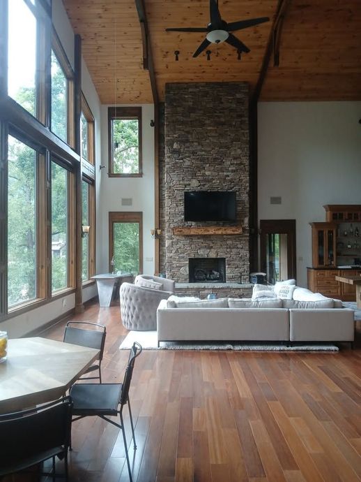 A living room with a couch , coffee table , and zebra print ottoman.