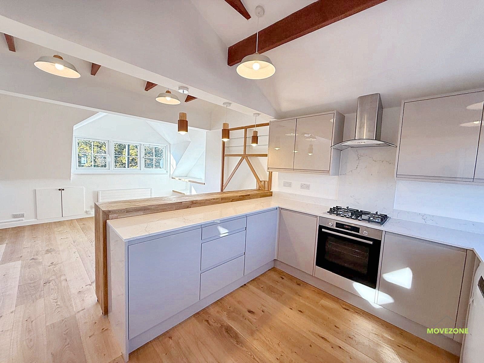 Bright modern kitchen with white cabinets, wood floors, and light gray island cabinets