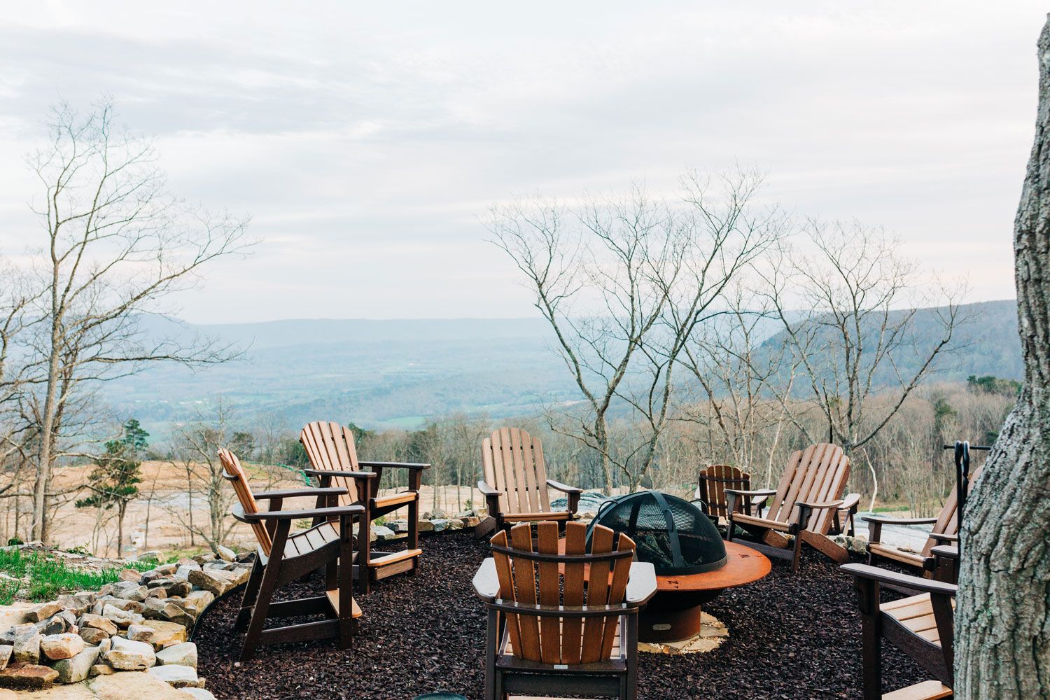 Fire pit with Adirondack chairs overlooking a hazy mountain view