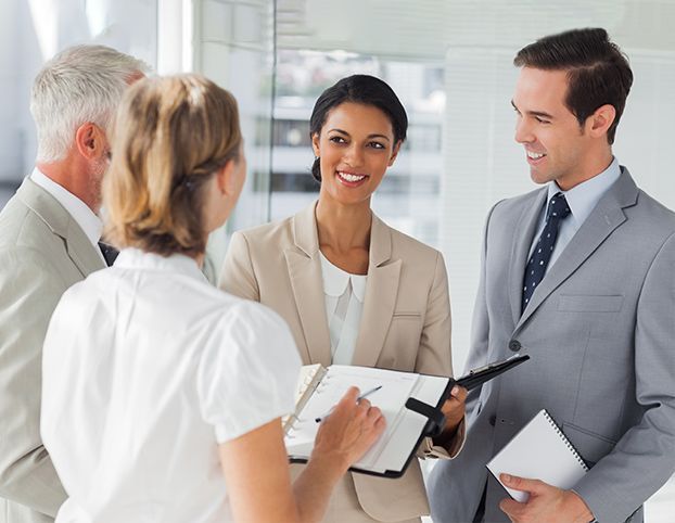 Business team in a bright office discussing with a clipboard and notebook