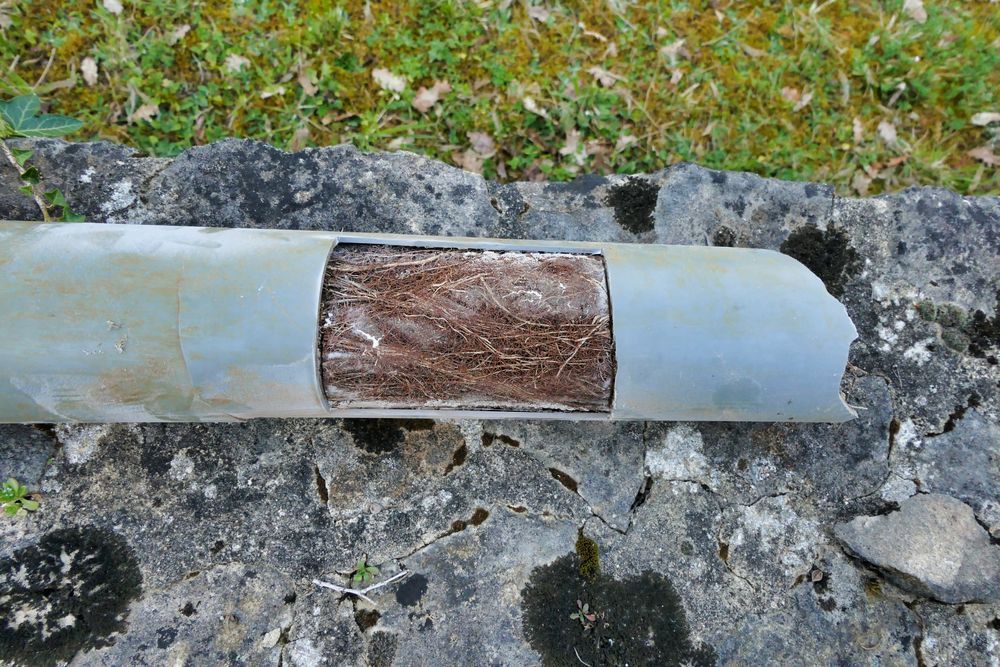 Cut Section of a Gray PVC Pipe Revealing a Wooden Core — Gibson Plumbing & Roofing Pty Ltd in Boyne Island, QLD