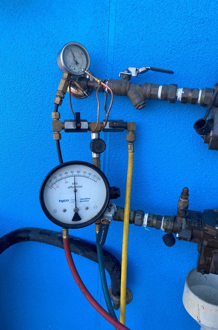 Two Pressure Gauges With Colored Hoses on Metal Pipes — Gibson Plumbing & Roofing Pty Ltd in Gladstone Central, QLD