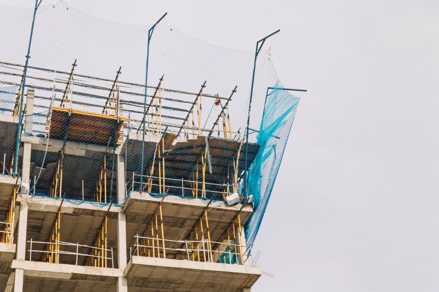 Se está construyendo un gran edificio con andamios y puntales metálicos.