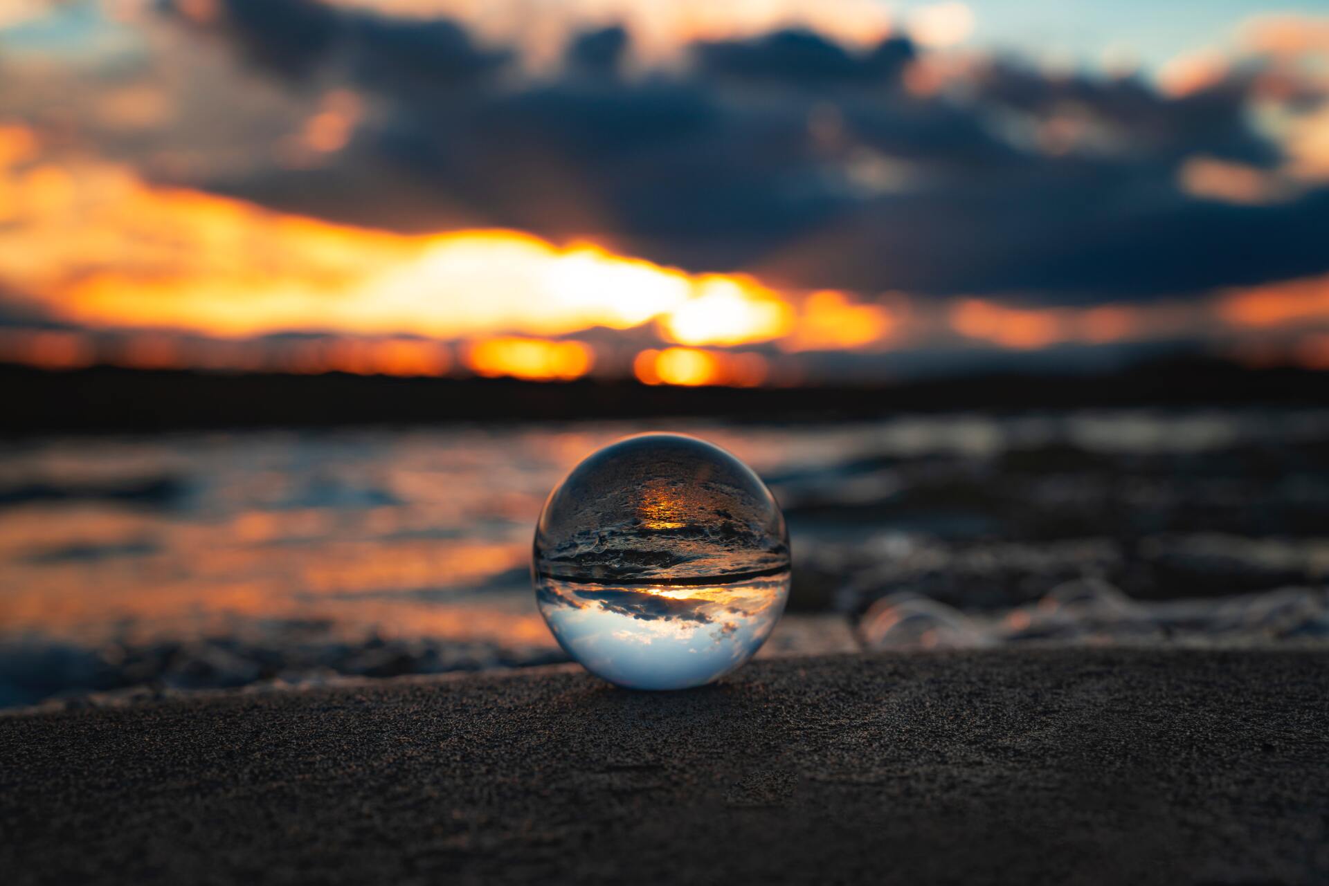 a glass sphere looking over the ocean shore