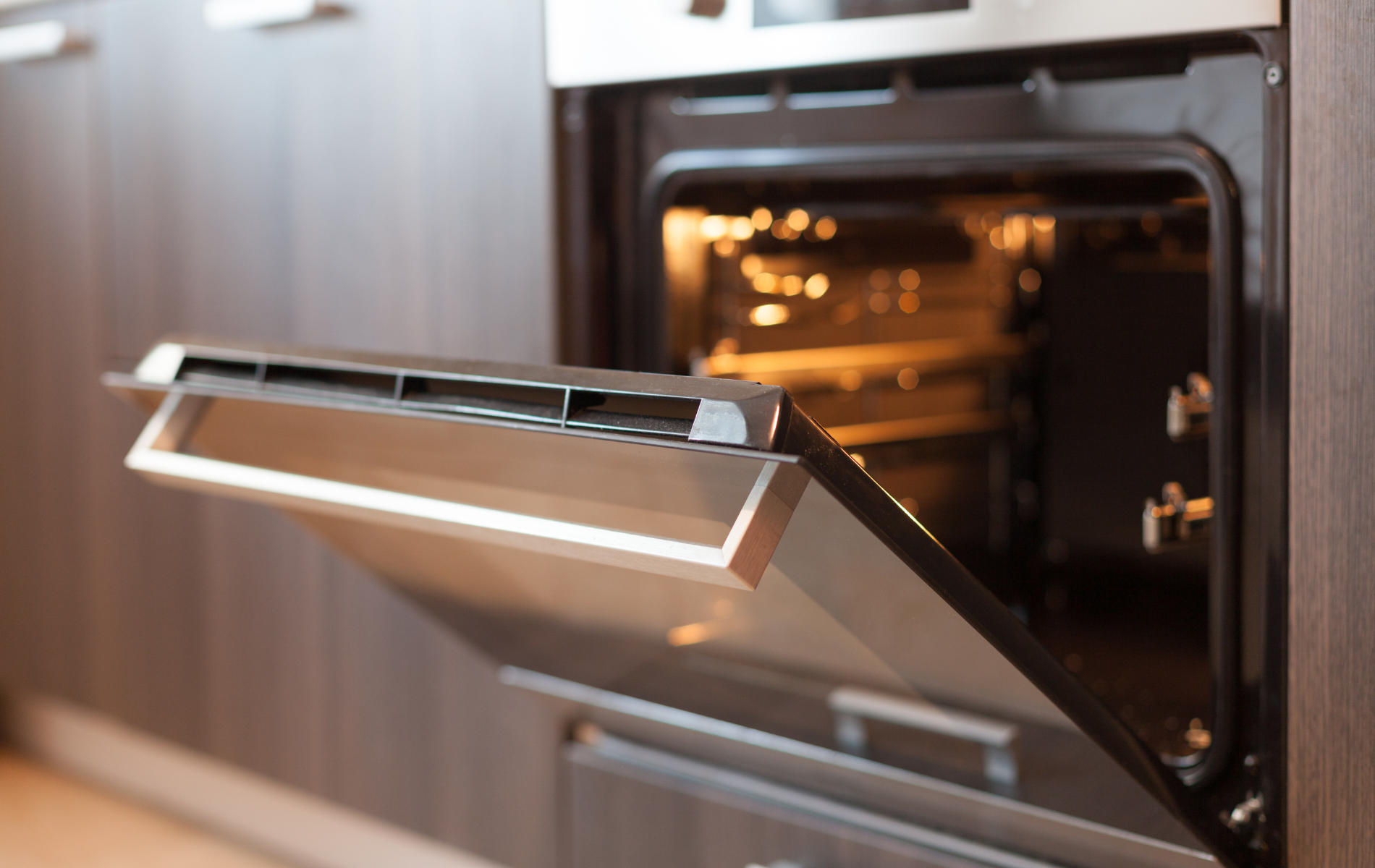 A stainless steel oven with the door open in a kitchen.