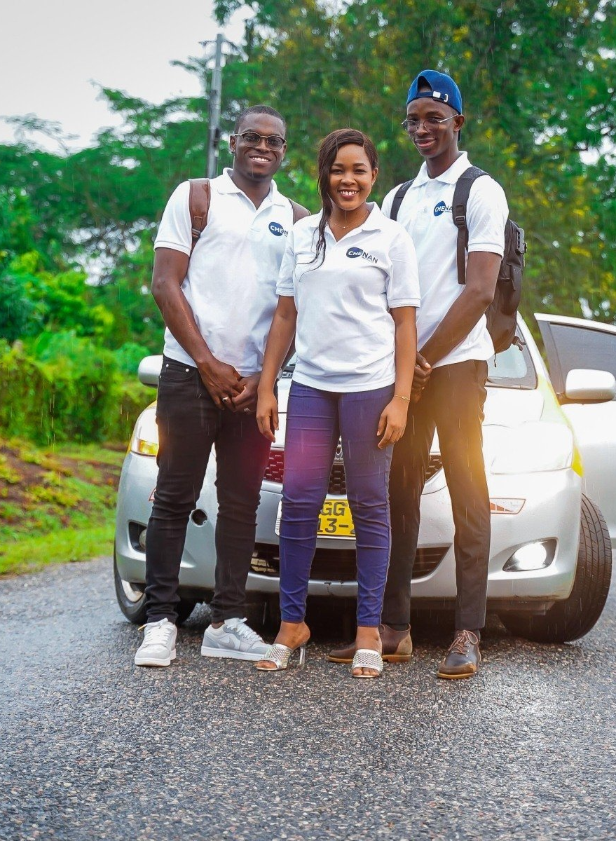 Trois apprenants de Chenan Africa posent pour une photo devant une voiture.