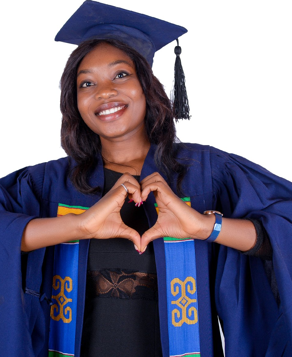 Une femme en robe de remise de diplôme forme un cœur avec ses mains.