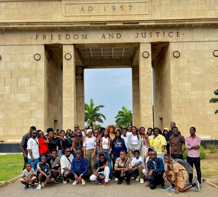 Groupe de personnes posant devant une arche portant l'inscription « Liberté et Justice ».