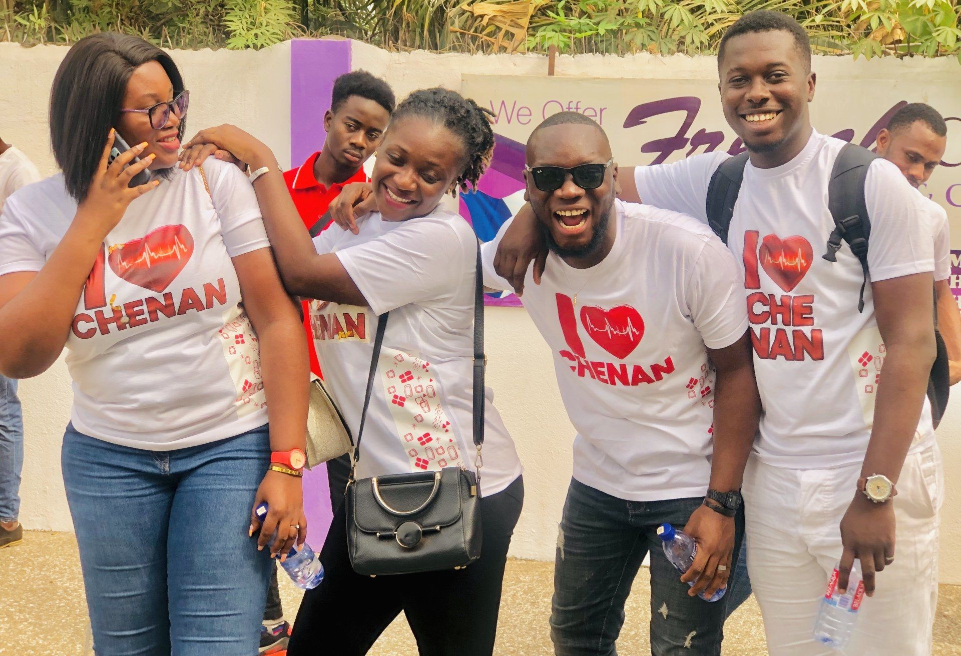 Groupe de personnes portant des t-shirts « J’❤️ Chenan » ; souriantes, posant à l’extérieur.