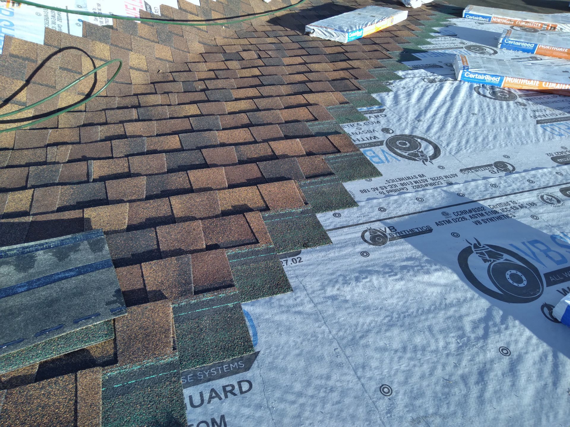 Northgate class 4 impact resistant laminated shingles being installed past a roof valley intersection in Pelican Rapids, MN