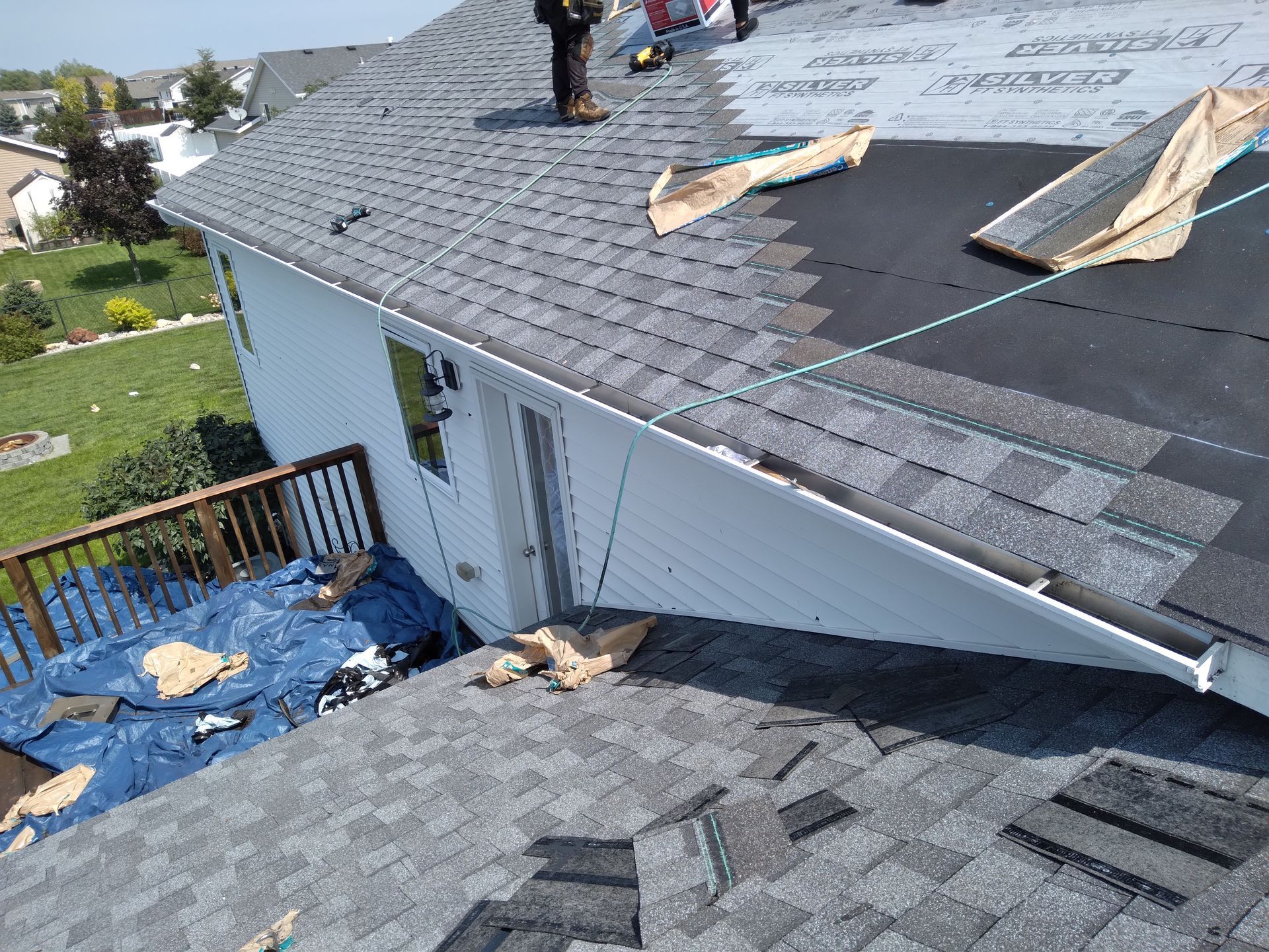 Roof shingles installed with air tools on top of ice and water barrier with synthetic felt underlayment near Ada, MN