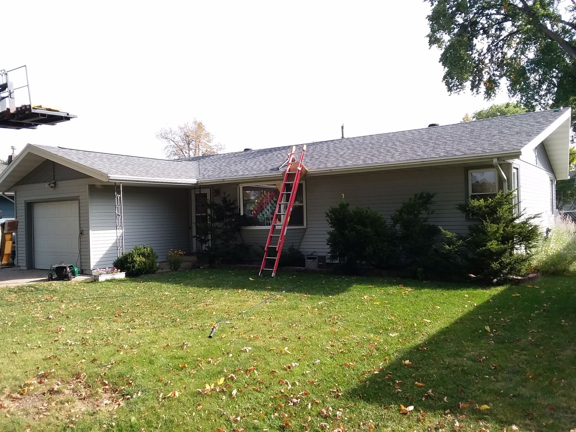 Roofer finished installing new class 4 shingles and vent flashings on a home with use of a telescopic forklift in Hawley, MN