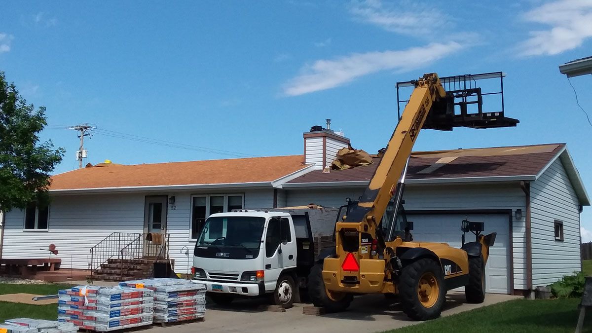 Telehandler, Dump Truck and Roof Shingle Bundles on the Ground at Project in Detroit-Lakes-Minnesota