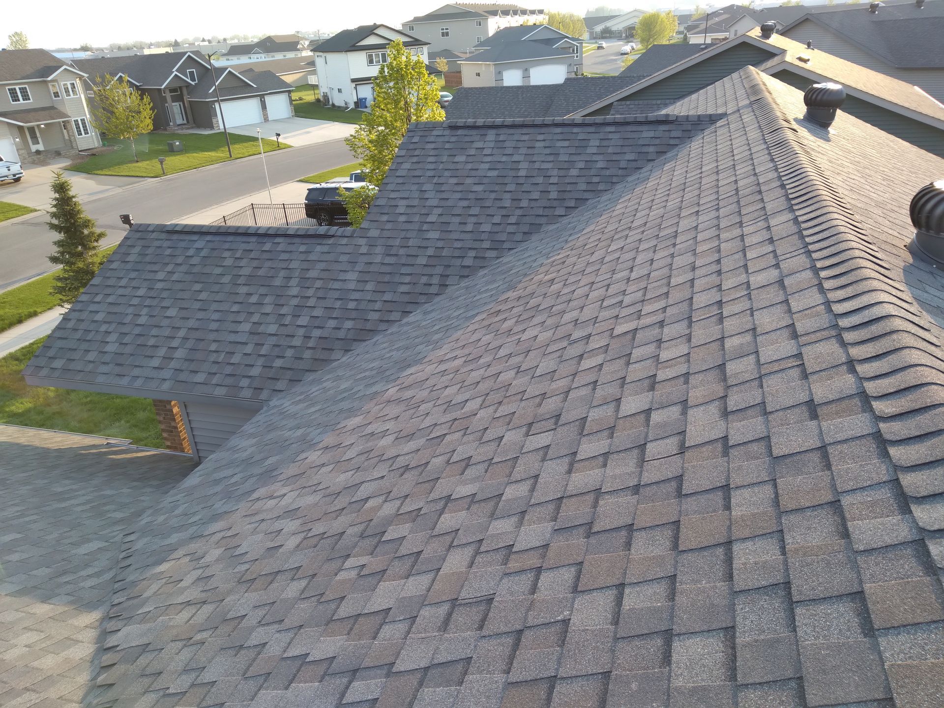 Northgate Driftwood colored shingle roof installed with whirlybird turbine and ridge exhaust vents in Pelican Rapids, MN