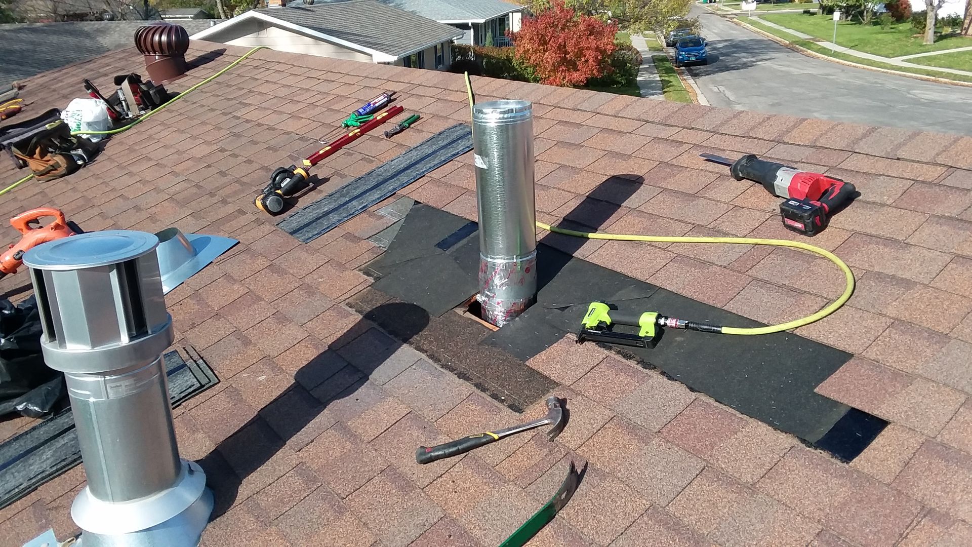 Roofer completing a leak repair on a type-b metal vent base-flashing, storm-collar and rain-cap near Fargo-ND-Moorhead-MN