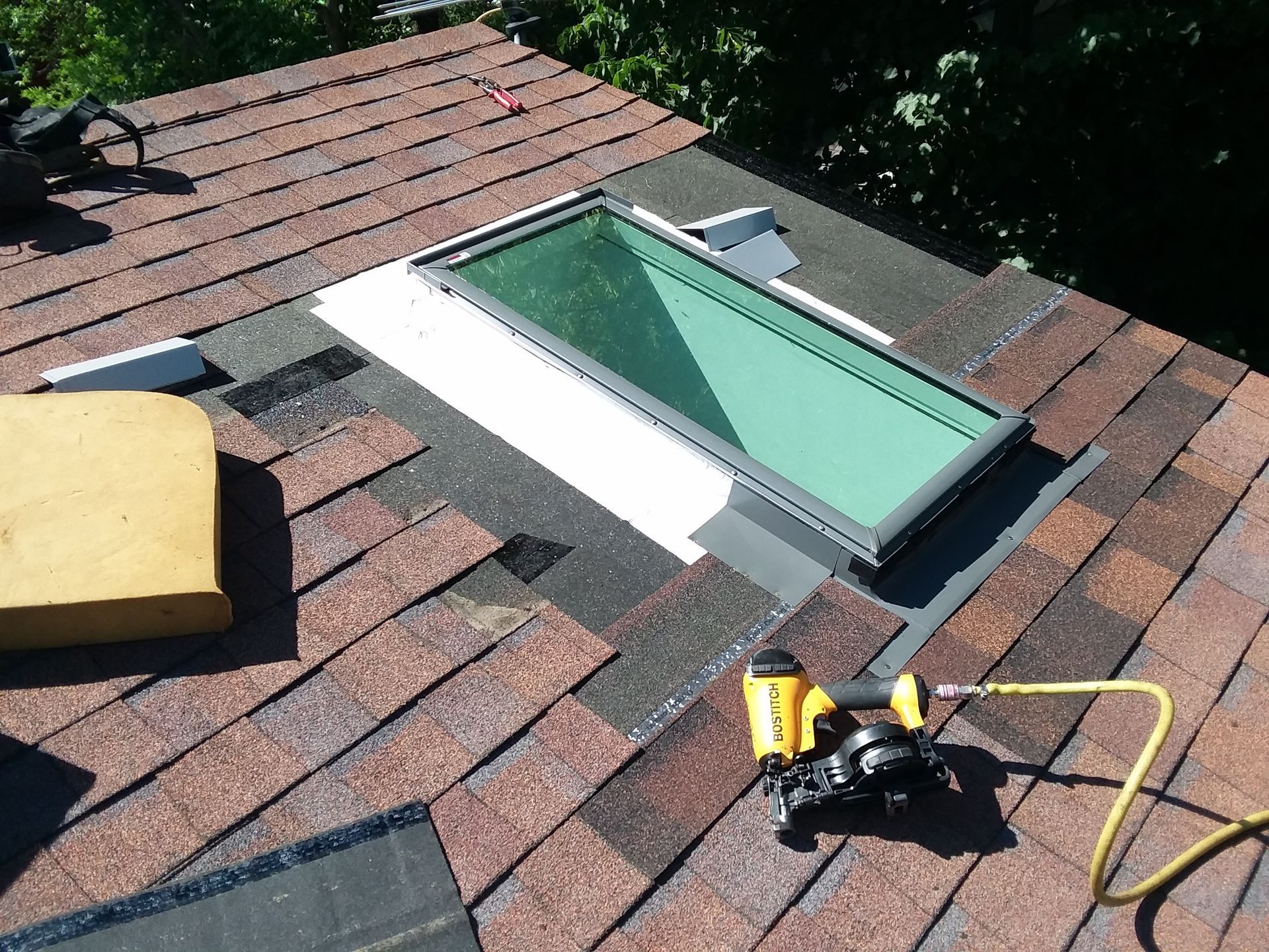 Leaking roof skylight window replaced using a new metal flashing kit, pneumatic tool and hand tools near Fargo-Moorhead