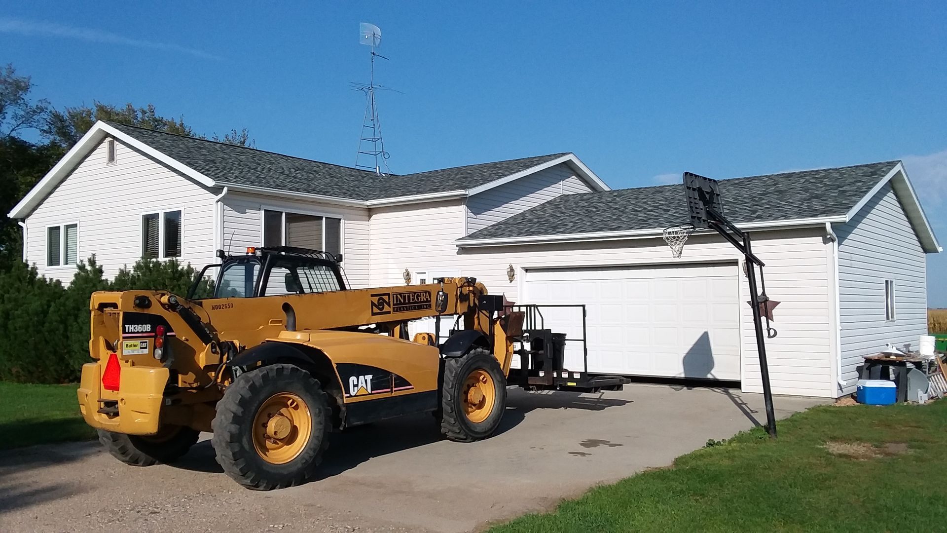 Roof in Valley City, ND installed with Northgate Class 4 Asphalt Shingles in Granite Gray with white trim using a forklift