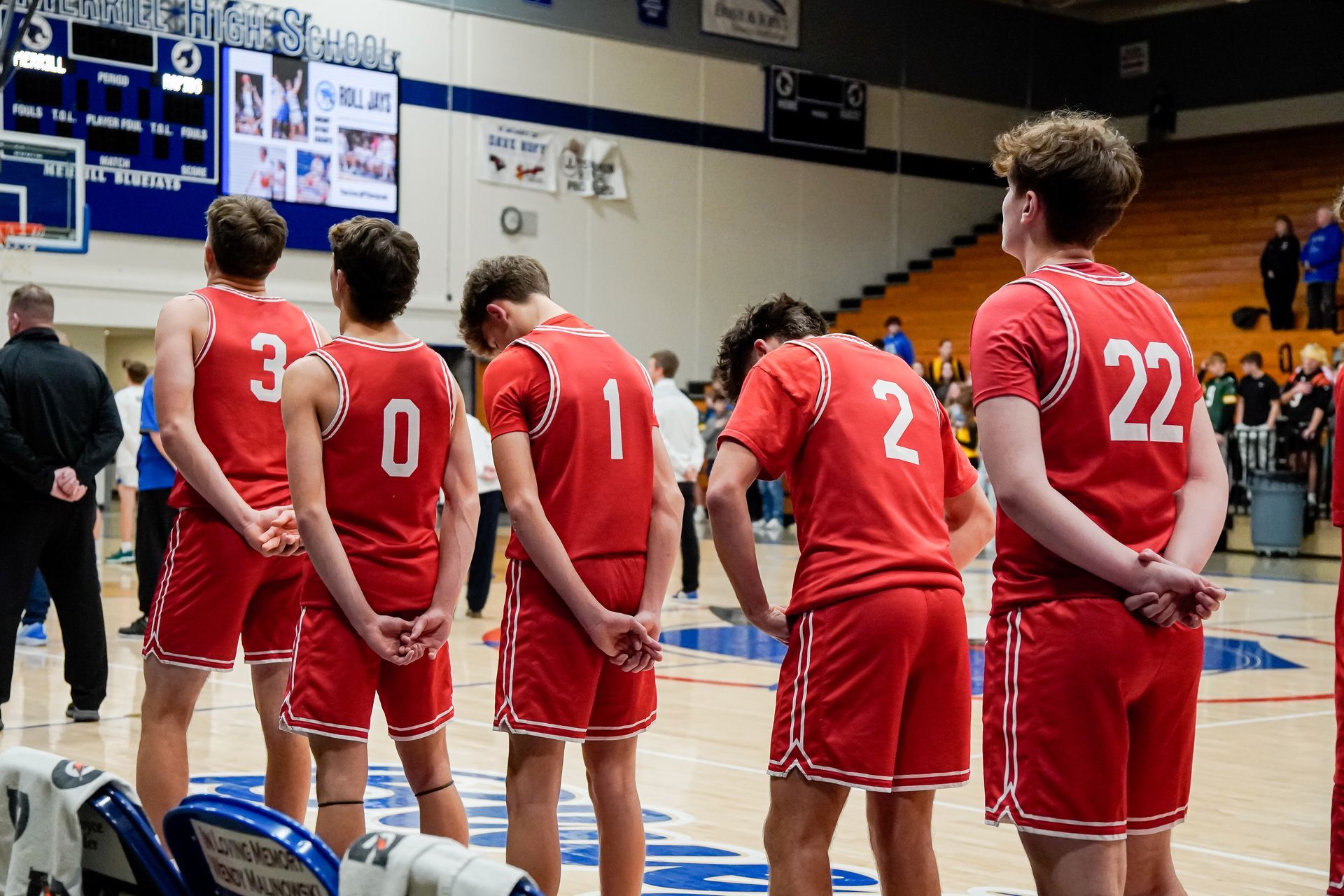 Basketball players in red uniforms standing on court during a game timeout