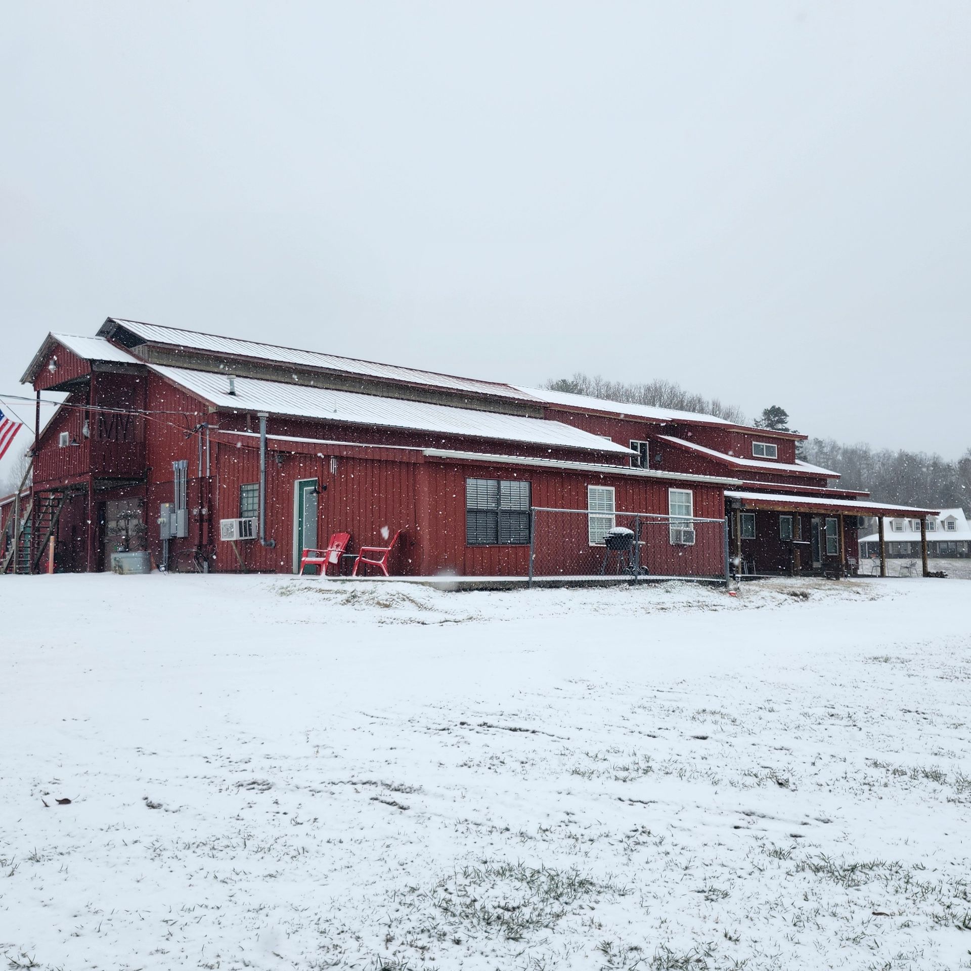 Red building in a snowy landscape during winter, with a few people near the entrance.