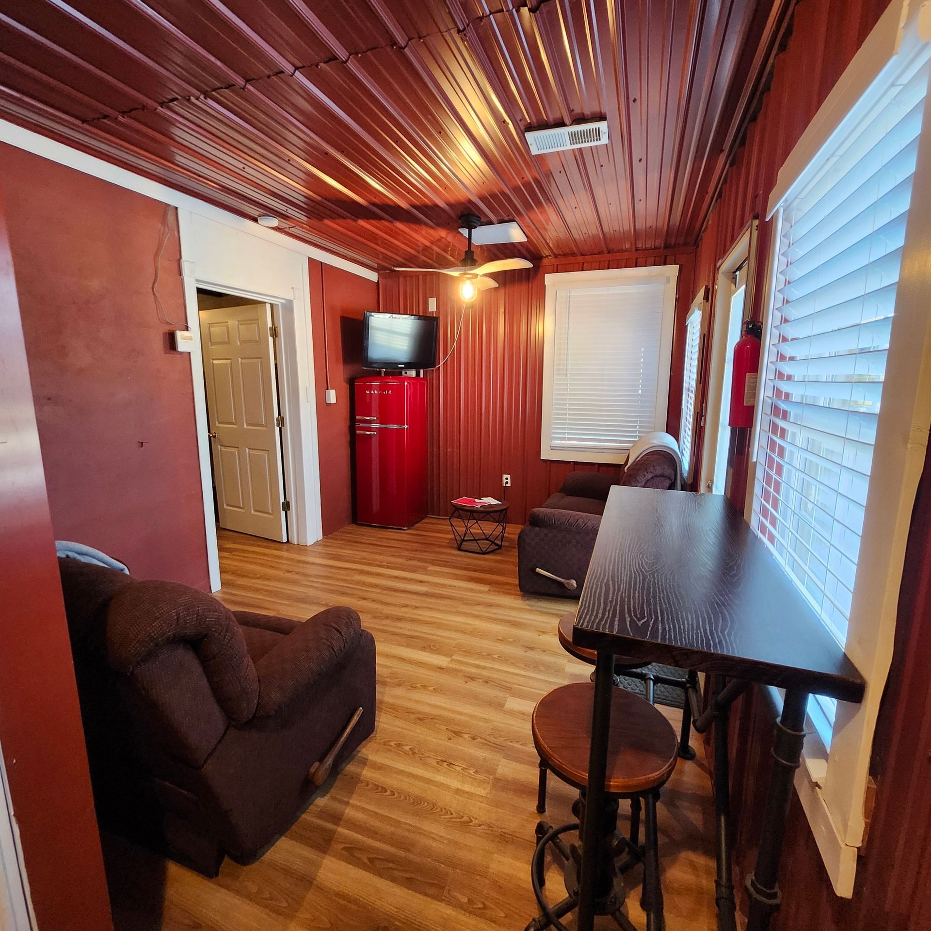 A room with four bunk beds and a door leading to a living room.