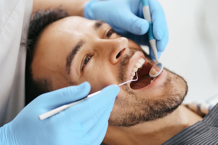 A dentist is looking at an x-ray of a patient 's teeth on a tablet. A dentist is looking at an x-ray of a patient 's teeth on a tablet.