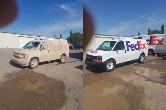 Two fedex vans are parked next to each other in a parking lot.