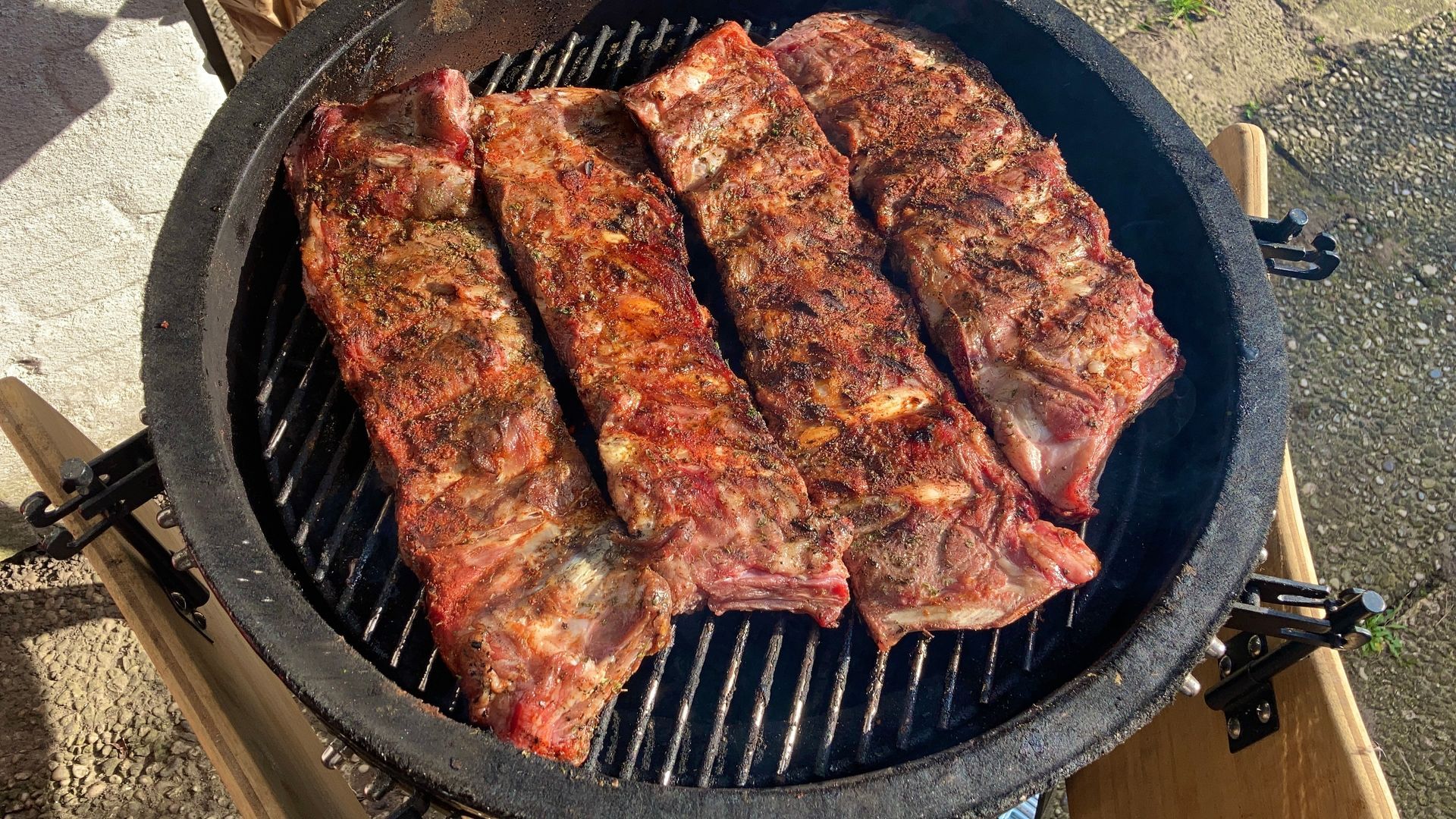 Drie ribben worden op een grill bereid.