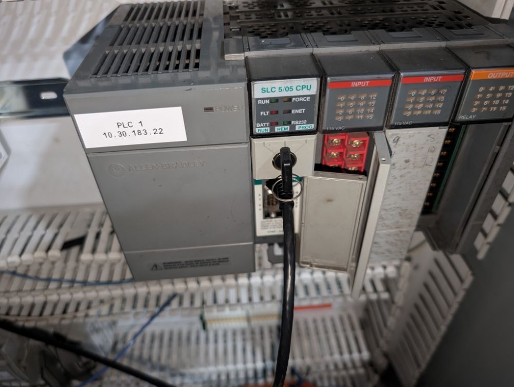 PLC control panel with various modules, including CPU, input, and output units.