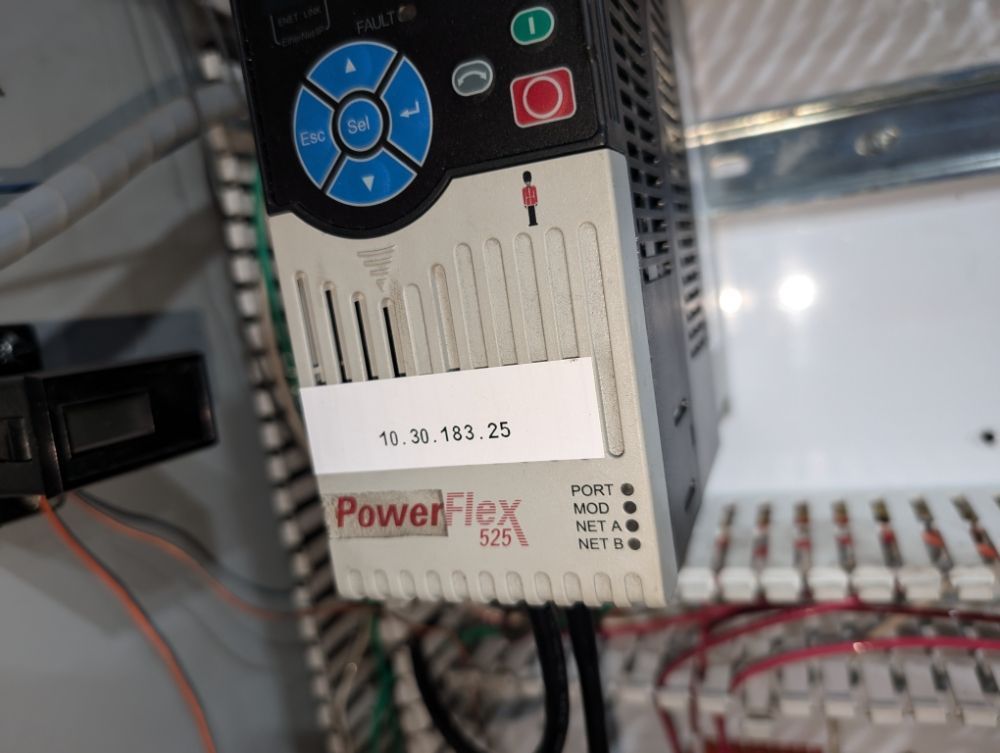 PowerFlex 525 drive with buttons and an IP address label (10.30.183.25) in an electrical panel.