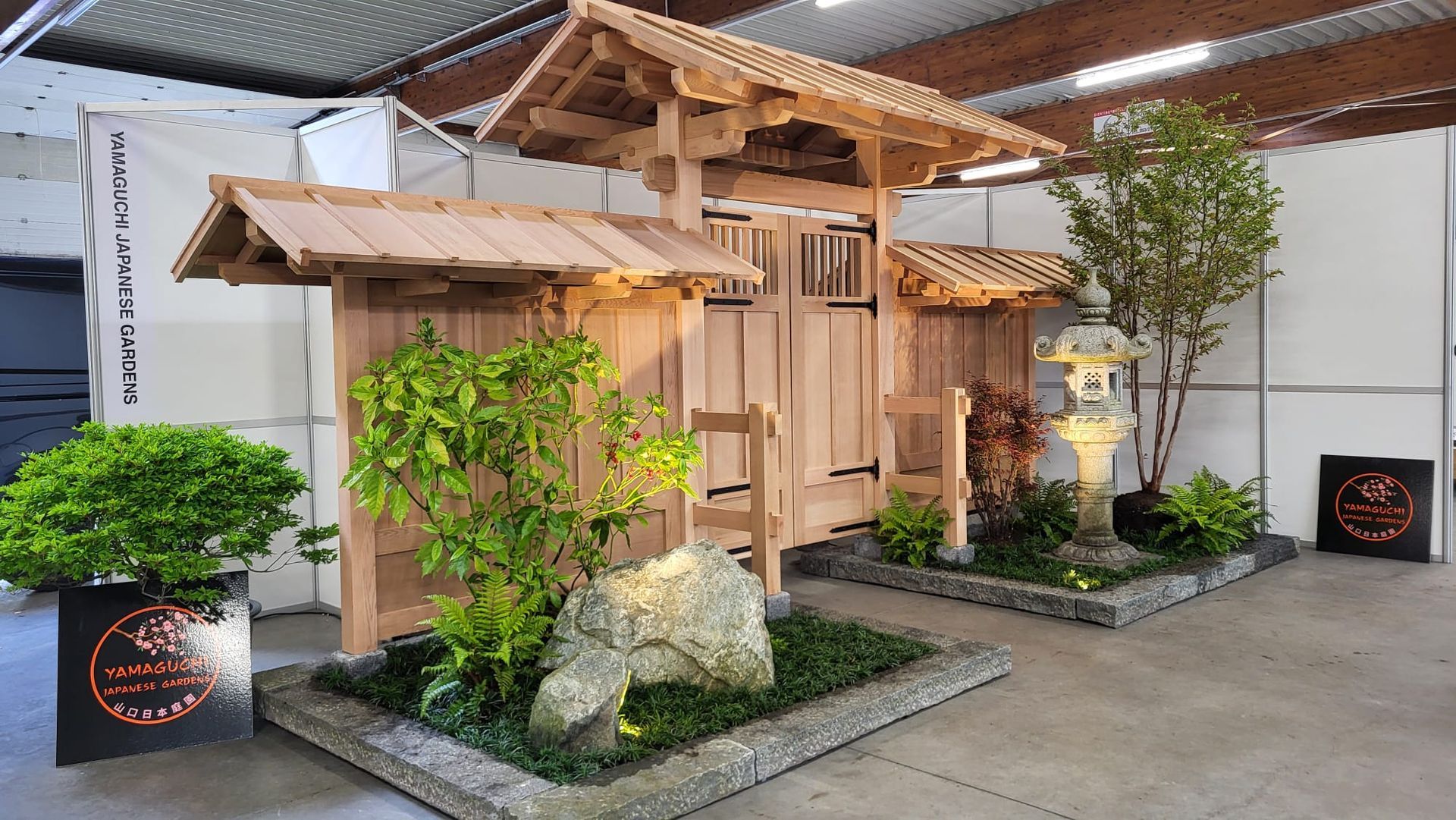 Een houten constructie met een dak en planten in een kamer.