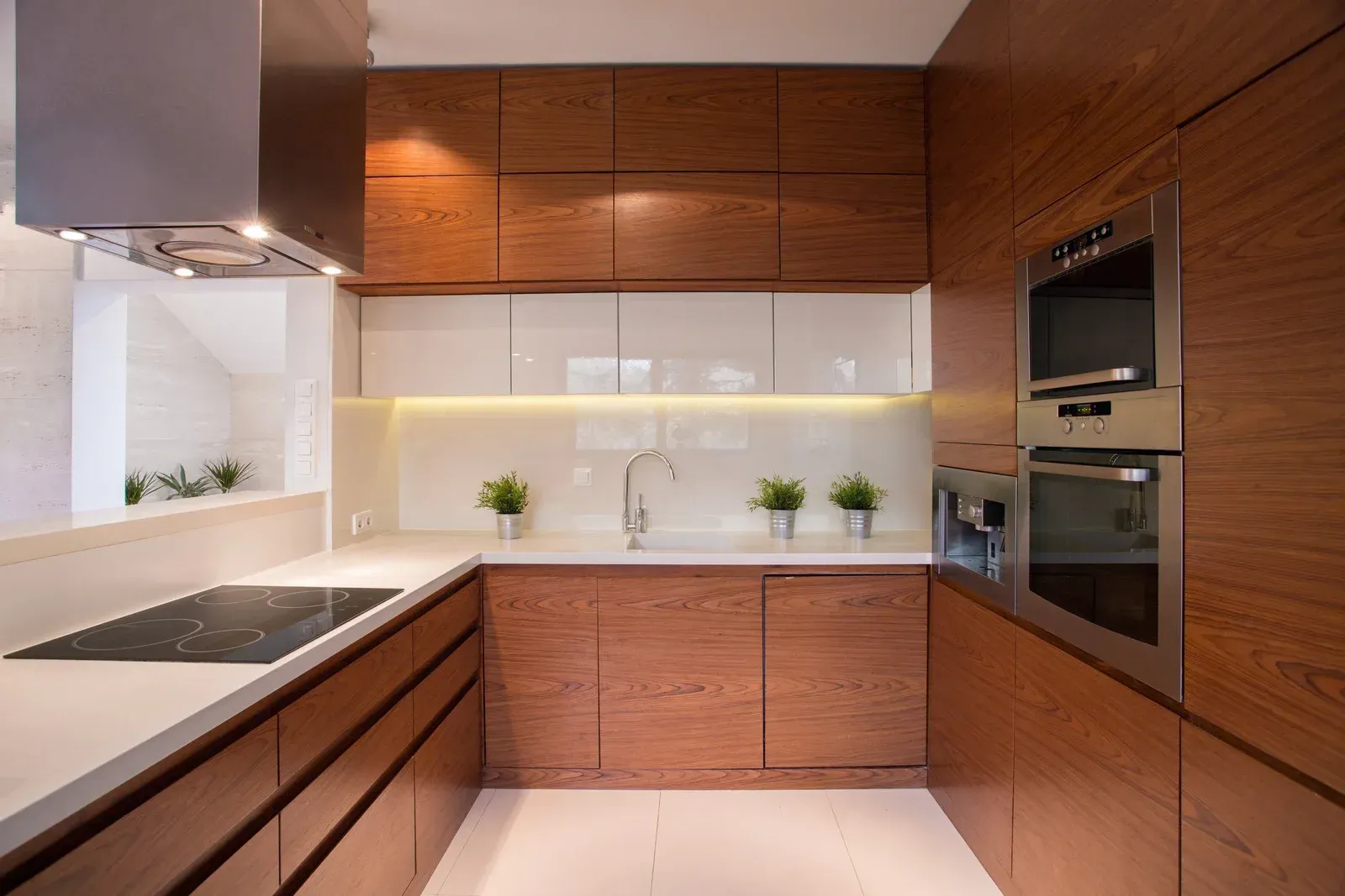 A kitchen with wooden cabinets , stainless steel appliances , and a stove top oven.