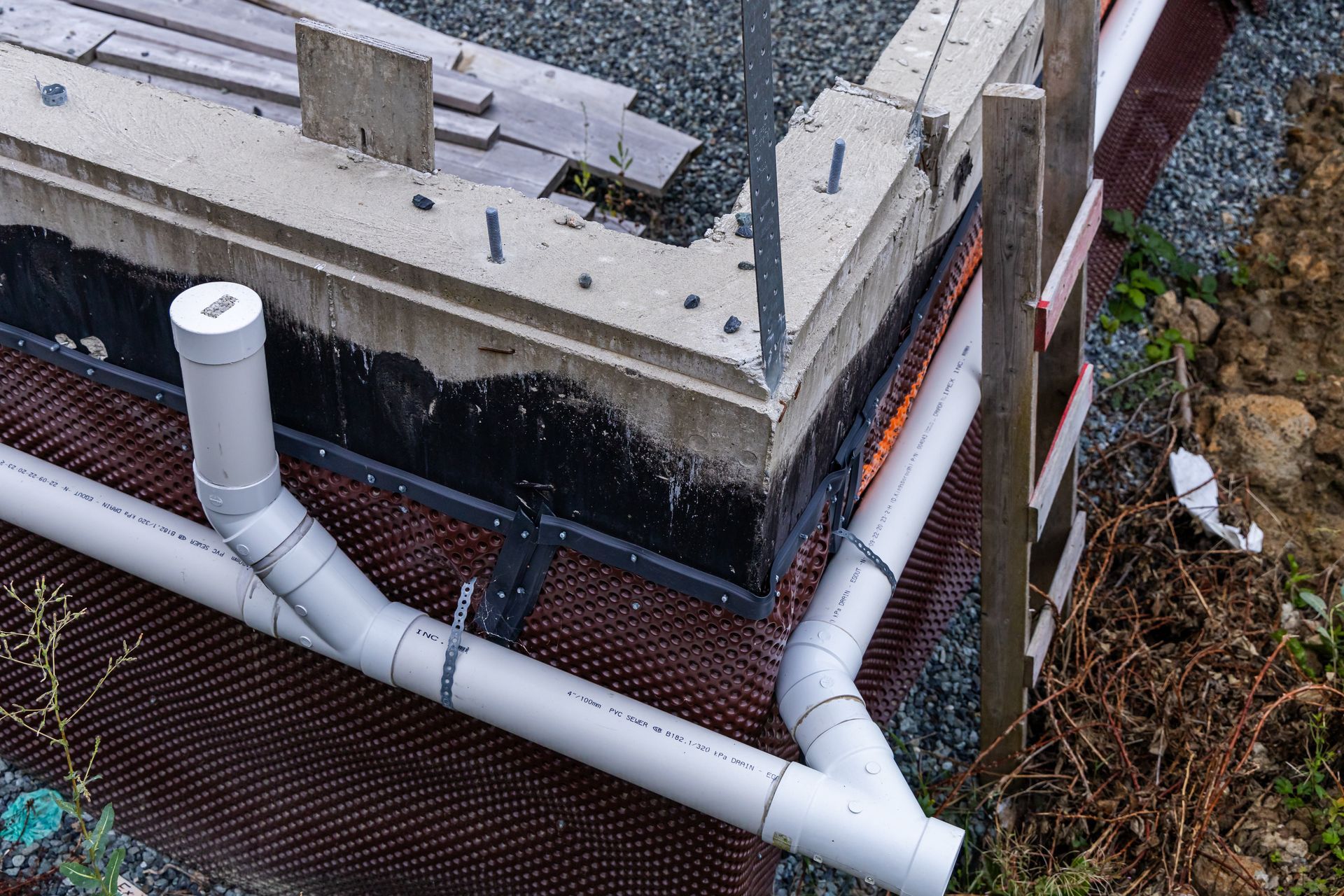 Un gros plan d'un tuyau d'évacuation sur le côté d'un bâtiment en construction.