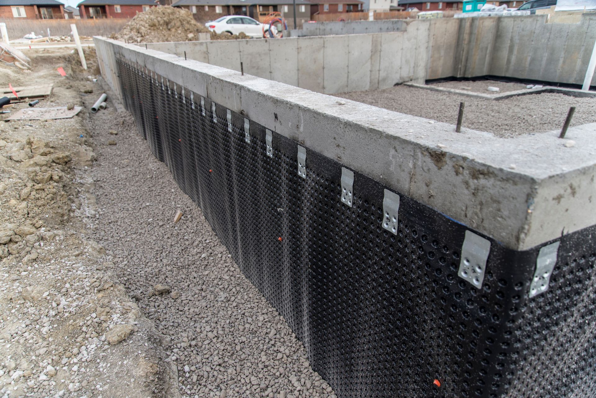 Un mur de béton est en train d'être construit sur du gravier.