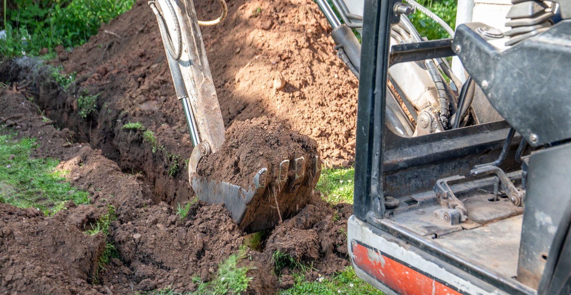 Un bulldozer creuse un trou dans le sol dans une cour.