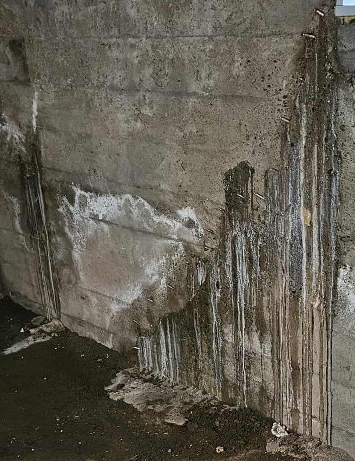 Un mur en béton avec beaucoup d'eau qui en sort.