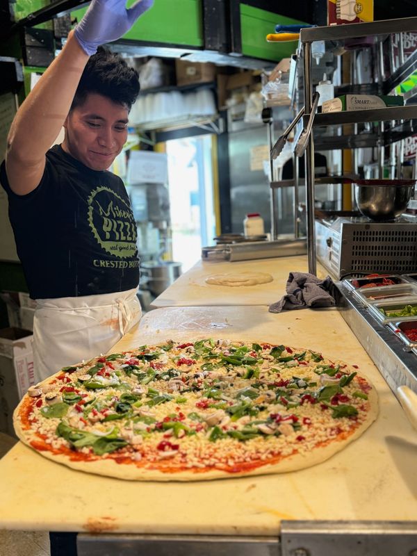 Two pizzas are stacked on top of each other on a plate.