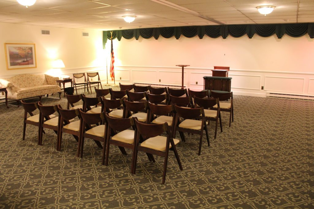 A room with rows of chairs and a podium in it.