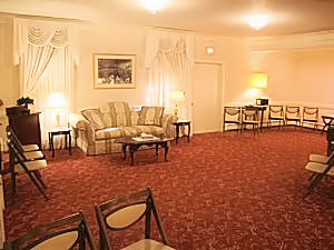A living room with a couch , table , chairs and a red carpet.