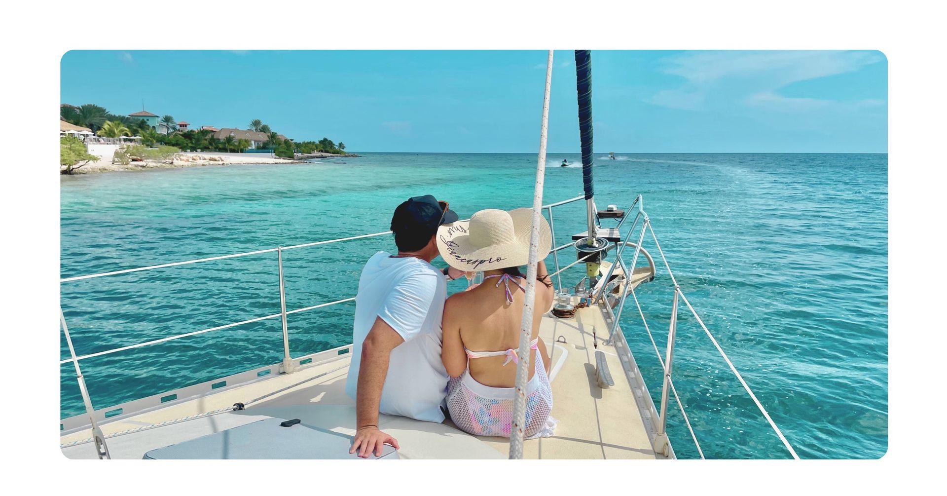 Romantic couple at the bow of green sailing yacht Galaxie on a private sunset cruise curacao