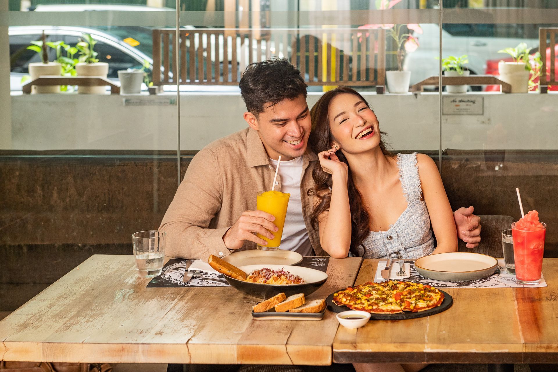 Happy couple dining with pizza and drinks at The Picasso Makati